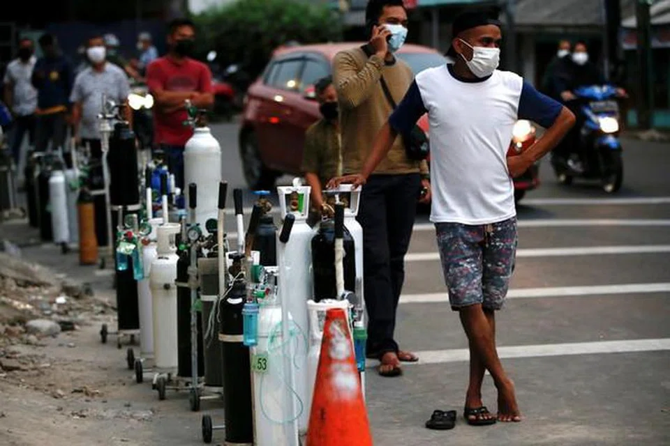 CEGAH RASUAH: Gambar fail penduduk mengenakan pelitup sebagai pelindung diri terhadap Covid-19 di Jakarta beratur untuk mengisi semula tangki oksigen ketika Indonesia mengalami kekurangan bekalan oksigen di tengah-tengah lonjakan kes penyakit koronavirus (Covid-19) pada 5 Julai 2021. 