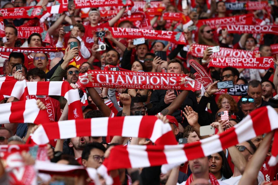 Penyokong Liverpool yang memenuhi stadium meraikan pasukan mereka mengangkat piala Liga Perdana England (EPL). 