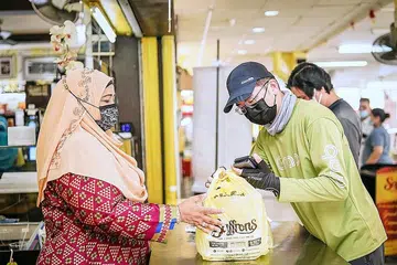 GUNA PELBAGAI WADAH: Pemilik kedai kopi Saffrons, Cik Kader Beevi Mohd Ayoob (kiri), menggunakan beberapa khidmat penghantaran makanan, tetapi yang paling banyak membawa masuk tempahan bagi perniagaannya buat masa ini adalah GrabFood. - Foto BH oleh NUR DIYANA TAHA