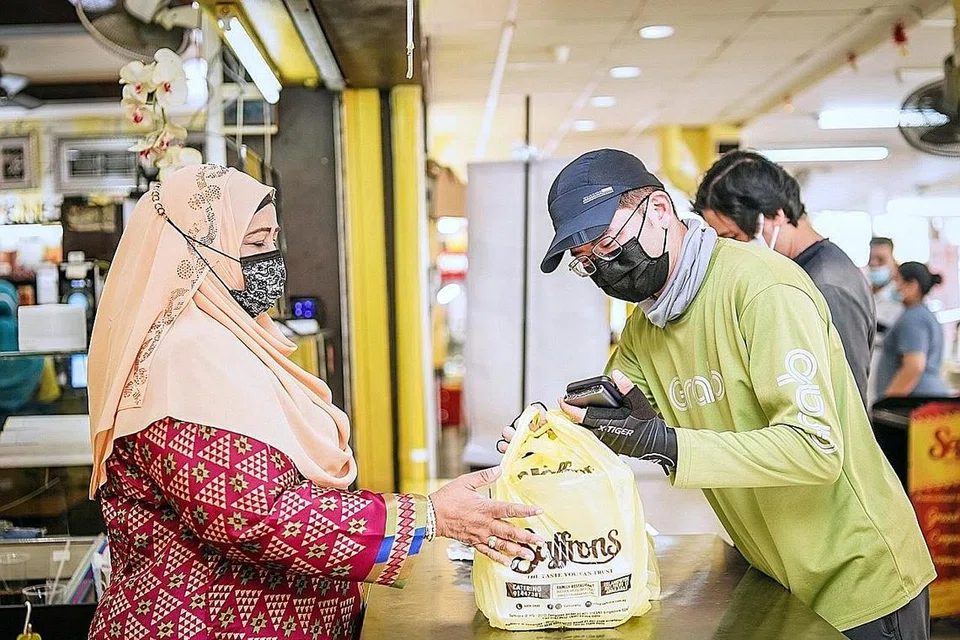 GUNA PELBAGAI WADAH: Pemilik kedai kopi Saffrons, Cik Kader Beevi Mohd Ayoob (kiri), menggunakan beberapa khidmat penghantaran makanan, tetapi yang paling banyak membawa masuk tempahan bagi perniagaannya buat masa ini adalah GrabFood. - Foto BH oleh NUR DIYANA TAHA