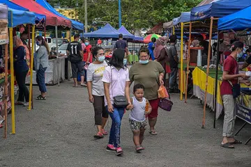 SIKAP WARGA: Sekumpulan warga kelihatan mengunjungi sebuah pasar di Karak, Pahang. Sikap sambil lewa tentang pemakaian pelitip yang diambil sebilangan rakyat telah menyumbang kepada peningkatan kes Covid-10 di dalam negara kata pakar kesihatan. - Foto AFP