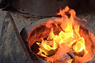 Tembikar yang sudah dikeringkan di dalam relau – dapur atau tempat membakar tembikar – dikeluarkan lalu dicampakkan ke dalam bekas berisi habuk kayu.