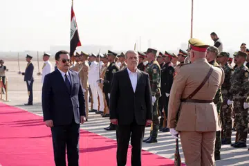 Perdana Menteri Iraq, Encik Mohammed Shia Al Sudani (kiri), menyambut kehadiran Presiden Iran, Encik Masoud Pezeshkian (tengah depan), semasa upacara sambutan rasmi di Lapangan Antarabangsa Baghdad pada 11 September.