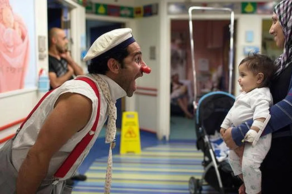 MENGHIBURKAN KANAK-KANAK: Seorang doktor badut dilihat sedang menghiburkan seorang kanak-kanak di sebuah hospital di Baitulmakdis. - Foto WWW.ZIMBIO.COM 
