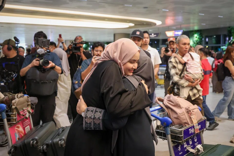 Pelajar tahun kedua di Universiti Yarmouk, Raja Nur Syakirah Raja Muzaffar Shah (kiri), memeluk erat ibunya, Cik Saadiah Mohd Habib, sejurus selepas beliau mendarat di Terminal 2 (T2) Lapangan Terbang Changi dari Jeddah, Arab Saudi pada dinihari 13 Mac. 