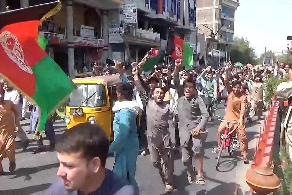 TUNJUKKAN BANTAHAN: Sekumpulan penduduk bandar Jalalabad di timur Afghanistan membawa bendara negara itu semasa melakukan bantahan anti-Taleban kelmarin. Kumpulan itu terlah berjanji tidak akan membalas dendam terhadap musuhnya dan akan menghormati hak wanita dalam kerangka syariah. - Foto REUTERS