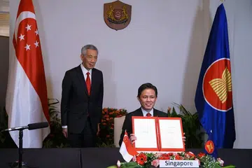 Menteri Perdagangan dan Perusahaan, Encik Chan Chun Sing (kanan), bersama Perdana Menteri Lee Hsien Loong, bergambar dengan dokumen selepas majlis pemeteraian RCEP pada 15 November. 