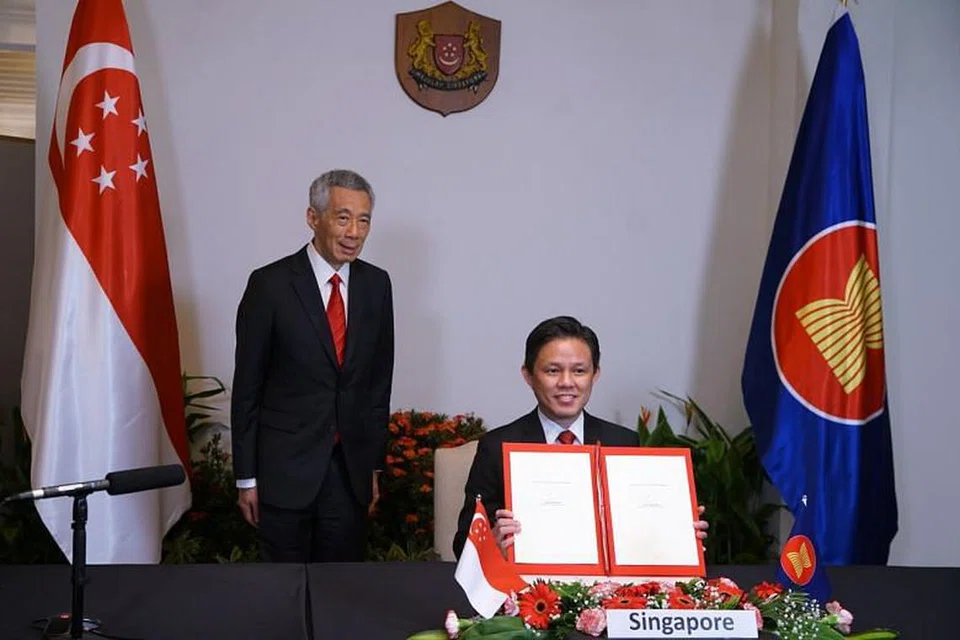 Menteri Perdagangan dan Perusahaan, Encik Chan Chun Sing (kanan), bersama Perdana Menteri Lee Hsien Loong, bergambar dengan dokumen selepas majlis pemeteraian RCEP pada 15 November. 