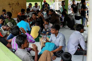 CARI PERLINDUNGAN: Antara pelarian lelaki Rohingya berehat di perkarangan masjid baru-baru ini menyusuli ketibaan mereka di Bireuen, Aceh, Indonesia, bersama pelarian wanita dan kanak-kanak yang semuanya berjumlah 114 orang. - Foto AFP