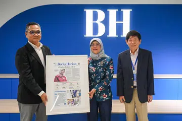 SUMBANGAN DISANJUNG: Editor BH, Encik Nazry Mokhtar (kiri), dan Pengerusi SPH Media Trust, Encik Khaw Boon Wan, menyampaikan cenderamata kepada mantan Presiden Singapura, Puan Halimah Yacob. 