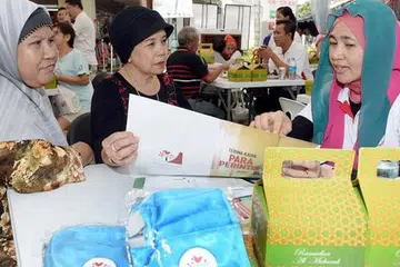 DAPAT PENJELASAN: Cik Ruhani Ismail (tengah), ditemani kawan baiknya Cik Saadiah Abdul Rahim (kiri), dalam sesi perundingan Pakej Generasi Perintis di Joo Chiat Complex. - Foto TAUFIK A. KADER