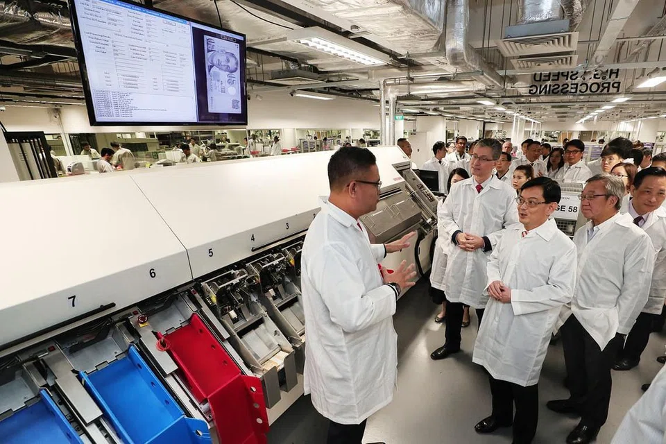 TINGKAT DAYA PENGHASILAN: Encik Heng mendengar taklimat mengenai teknologi terkini yang Certis gunakan. - Foto BH oleh KELVIN CHNG