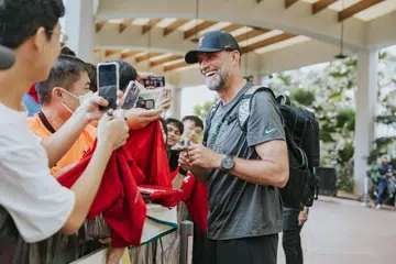 TEMUI PEMINAT: Pengurus Liverpool Jurgen Klopp beramah mesra dengan peminat yang berkumpul di hotel The Ritz Carlton pada Jumaat.