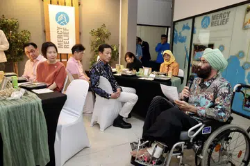 Pengerusi Mercy Relief, Encik Satwant Singh (kanan, berkerusi roda), berucap dalam majlis iftar di pejabat badan tersebut pada 20 Mac. Antara mereka yang hadir dalam majlis tersebut adalah Menteri Kesihatan, Encik Ong Ye Kung (empat dari kiri), mantan Presiden dan Canselor Universiti Sains Kemasyarakatan Singapura (SUSS), Puan Halimah Yacob (dua dari kanan) dan Menteri Negara (Pendidikan merangkap Tenaga Manusia), Cik Gan Siow Huang (dua dari kiri).