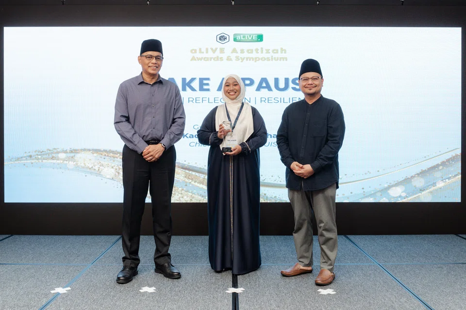 (dari kiri) Ketua Eksekutif, Majlis Ugama Islam Singapura (Muis), Encik Kadir Maideen bersama penerima Anugerah Asatizah Cemerlang, Ustazah Nur Al’Husainah Mohammed Ali dan Pengarah Eksekutif ILHAM (pejabat yang mengendali program aLIVE), Ustaz Muhammad Hafiz Abdul Rashid di Majlis Anugerah dan Simposium aLIVE Asatizah (AAAS) 2025. 