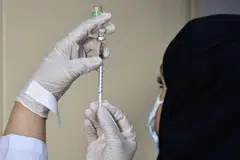 VAKSINASI WAJIB: Seorang pekerja perubatan menyiapkan vaksin Covid-19, AstraZeneca, di pusat vaksinasi sekitar Riyadh. Mulai 1 Ogos, sesiapa yang ingin masuk pejabat atau bangunan kerajaan serta sektor swasta diperlukan menjalani vaksinasi. - Foto AFP/FAYEZ NURELDINE 