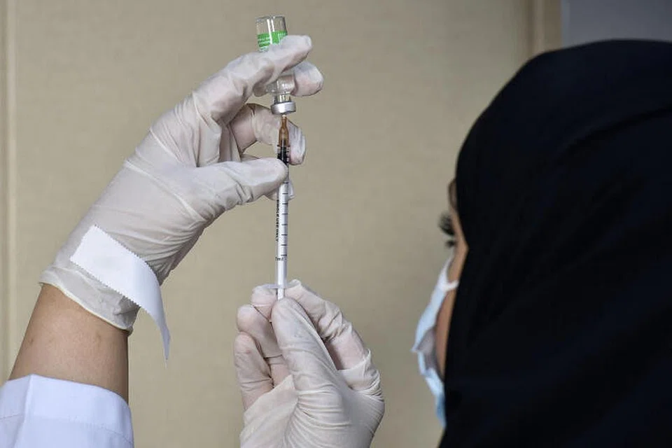 VAKSINASI WAJIB: Seorang pekerja perubatan menyiapkan vaksin Covid-19, AstraZeneca, di pusat vaksinasi sekitar Riyadh. Mulai 1 Ogos, sesiapa yang ingin masuk pejabat atau bangunan kerajaan serta sektor swasta diperlukan menjalani vaksinasi. - Foto AFP/FAYEZ NURELDINE 