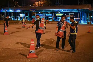 SIAP SEDIA: Anggota polis membuat persiapan menamatkan sekatan jalan di Lebuhraya Pantai Timur (Kuala Lumpur-Karak) selepas sekatan pergerakan rentas negeri yang dilaksanakan pihak berkuasa sebelum ini berakhir. - Foto AFP