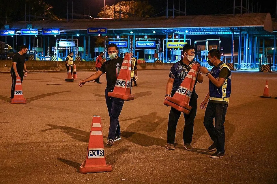 SIAP SEDIA: Anggota polis membuat persiapan menamatkan sekatan jalan di Lebuhraya Pantai Timur (Kuala Lumpur-Karak) selepas sekatan pergerakan rentas negeri yang dilaksanakan pihak berkuasa sebelum ini berakhir. - Foto AFP