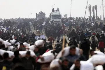 Rakyat Palestin melarikan kampit tepung yang mereka ambil daripada trak bantuan, berhampiran pusat pemeriksaan Israel.