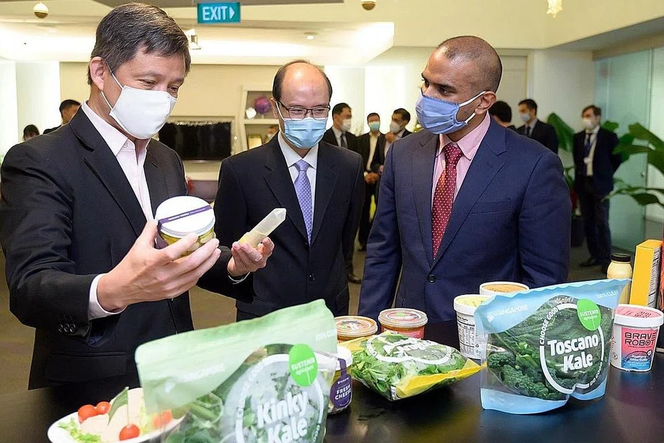 TEKNOLOGI MAKANAN PERTANIAN: Encik Chan Chun Sing (kiri) meninjau beberapa produk syarikat Perfect Day yang diperbuat daripada protein tenusu bebas haiwan semasa kunjungannya ke A*Star semalam. Bersamanya ialah Penolong Ketua Eksekutif Majlis Penyelidikan Bioperubatan A*Star, Profesor Ng Huck Hui (tengah), dan pengasas bersama Perfect Day, Encik Perumal Gandhi. - Foto MTI