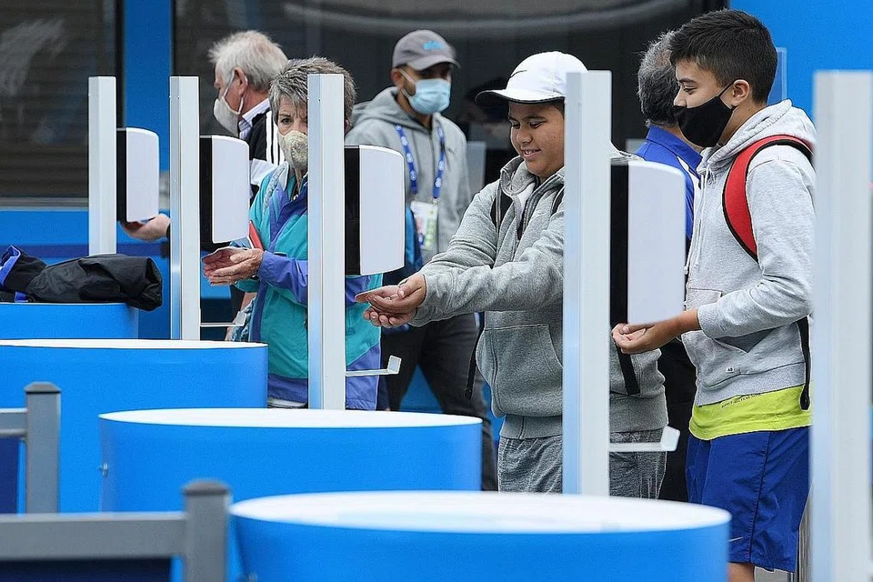 PATUHI PROTOKOL KESELAMATAN: Penonton Terbuka Australia menggunakan sanitiser tangan disediakan di Melbourne Park. - Foto EPA-EFE 