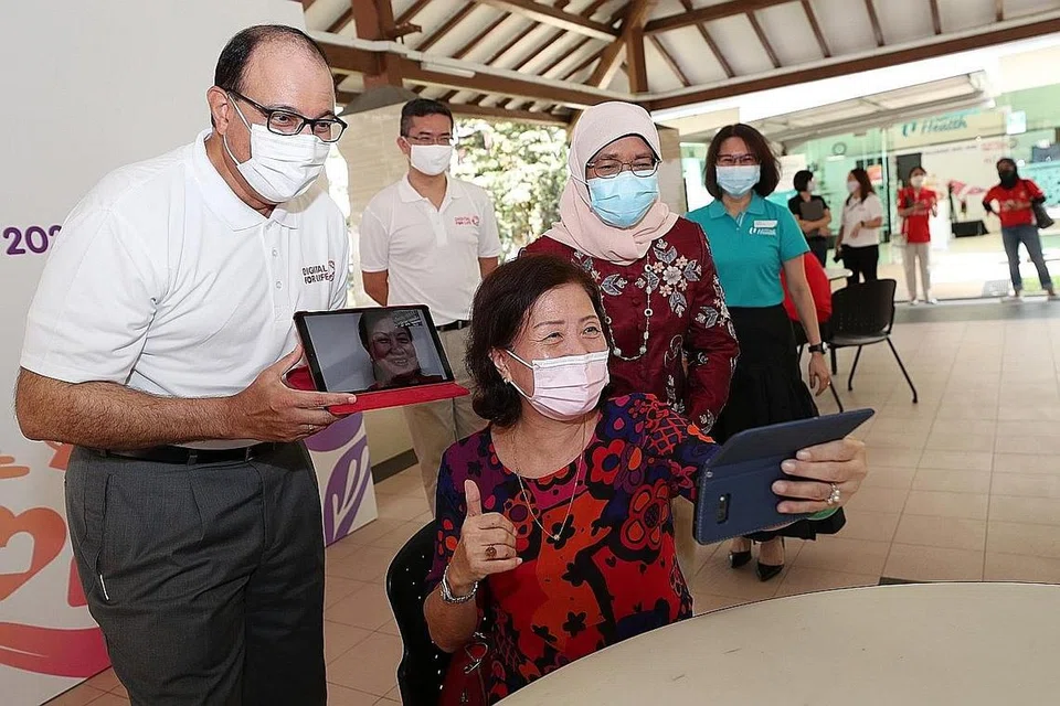 MENDAKAP GAYA HIDUP DIGITAL: (Kiri) Encik Iswaran dan Puan Halimah (kanan) berinteraksi dengan Cik Patsy Low (tengah) yang membuat panggilan video kepada ahli keluarganya. - Foto BH oleh TIMOTHY DAVID