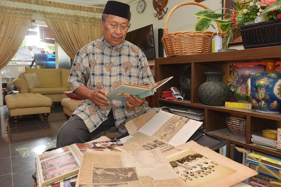 MENGGAMIT KENANGAN: Ustaz Ibrahim Abdul Razak menatap wajah murid-murid yang pernah diajarnya ketika mereka masih kecil dan ingin bertemu kembali dengan mereka setelah bertahun tidak bersua. - Foto TUKIMAN WARJI