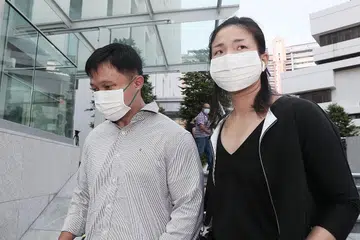 DIDAKWA: Karl Liew (kiri) yang ditemani wanita yang tidak dikenali didakwa di mahkamah semalam kerana memberikan maklumat dan bukti palsu berhubung kes bekas pembantu rumah keluarganya, Cik Parti Liyani. - Foto BH oleh KELVIN CHNG