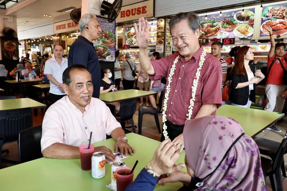 DEKATI WARGA: Calon Presiden, Encik Tan Kin Lian (tengah) bertemu penduduk semasa lawatannya di Pasar dan Pusat Makanan Chong Pang pada Ahad.