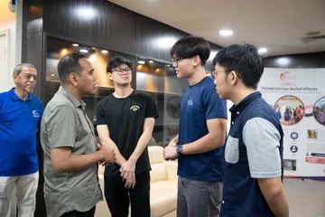 Menteri Negara (Kementerian Ehwal Luar merangkap Kementerian Dalam Negeri), Encik Zhulkarnain Abdul Rahim (kiri), beramah mesra dengan tetamu di acara RLAF yang menyampaikan Geran Masyarakat untuk menyokong projek belia. Beliau diiringi Pengerusi RLAF, Encik Abdul Razak Maricar (paling kiri).