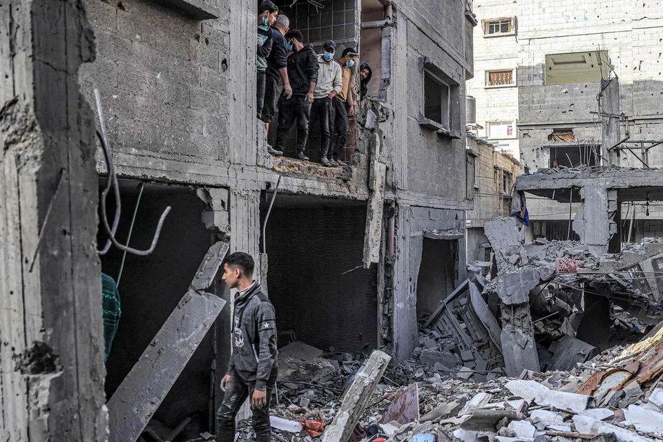 BANGUNAN MUSNAH: Orang ramai memeriksa runtuhan bangunan yang musnah akibat pengeboman Israel di Rafah di selatan Jaluran Gaza pada 24 Disember di tengah-tengah konflik berterusan antara Israel dengan Hamas.