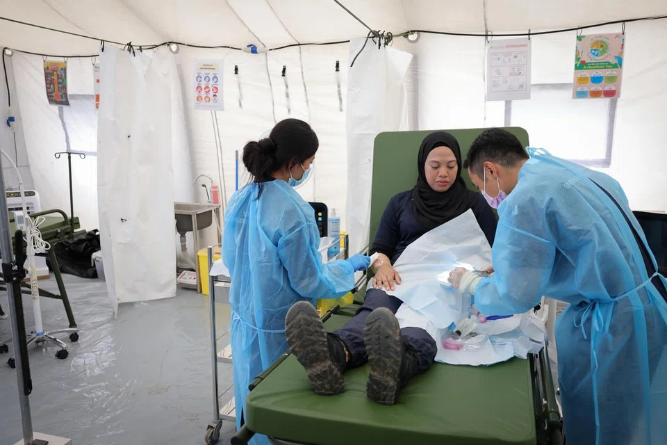 Demonstrasi rawatan di pangkalan operasi Pasukan Perubatan Kecemasan Singapura (SGEMT) semasa perasmian SGEMT pada 12 September.