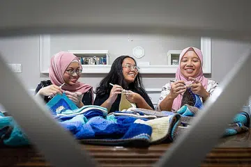 KAIT BERSAMA: Cik Noraizah Zainal Abidin (kanan), 45 tahun, mengait bersama anak-anaknya, Naifah Firzanah Mohd Faizal (kiri), 19 tahun, dan Nabihah Fadilah Mohd Faizal, 15 tahun. Cik Noraizah yang bekerja dalam perhubungan korporat di sebuah institut penjagaan kesihatan awam mula mengait ketika beliau berumur lapan tahun, tetapi melakukan semula hobinya itu beberapa tahun lalu untuk menghilangkan stres. - Foto BH oleh GAVIN FOO