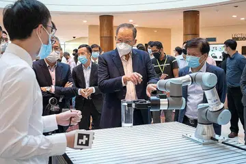 PUSAT PENYELIDIKAN ROBOTIK: Dr Tan See Leng (dua dari kanan) meninjau sebuah robot yang dipamerkan semasa acara perasmian Pusat bagi Inovasi Teknologi Robotik Lanjutan (Cartin) di NTU semalam. - Foto NTU
