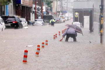 Seorang lelaki meredah jalan yang dinaiki air akibat hujan lebat di Gwangju, Korea Selatan, pada 17 Julai 2025.  