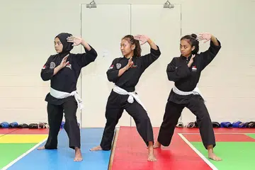 GERAK-GERI SEIRAMA: Anggota seni regu puteri (dari kiri gambar atas), Siti Nazurah, Nurzuhairah dan Nurul Syafiqah menunjukkan gerak-geri seirama semasa berlatih di Arena OCBC, Hab Sukan Singapura, sebagai persiapan menghadapi Kejohanan Pencak Silat Dunia Ke-18 yang bermula Khamis ini. Selain acara itu, Nurzuhairah juga akan turun beraksi dalam acara seni tunggal puteri. - Foto BH oleh JEREMY KWAN