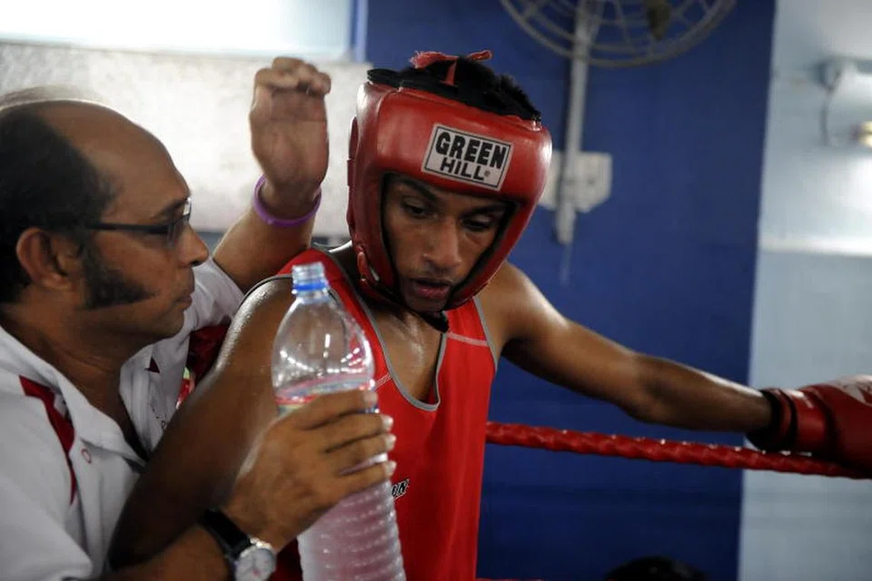 Syed Abdul Kadir (kiri) ketika melatih petinju Singapura, Mohd Hanurdeen Hamid pada 2010.