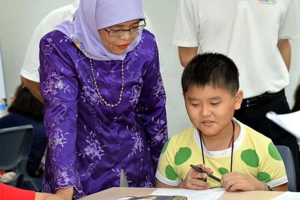 BANTUAN UNTUK PELAJAR: Cik Halimah Yacob melancarkan program Kelas Kemajuan Marsiling kelmarin, yang akan membantu pelajar daripada keluarga berpendapatan rendah dalam subjek Bahasa Inggeris dan Matematik secara percuma. - Foto PERSATUAN RAKYAT