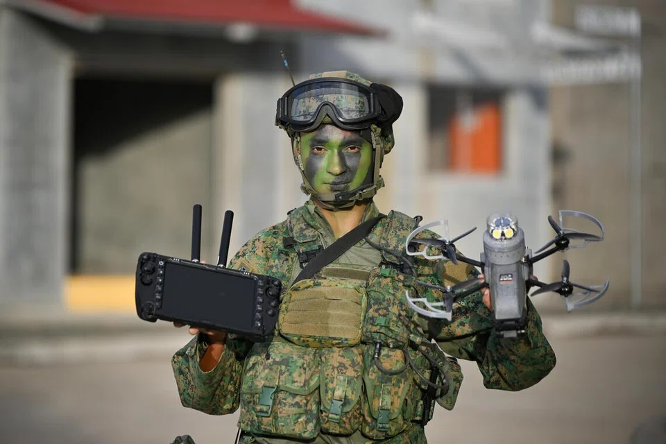 Komander Steel Net daripada Batalion Kelima Rejimen Infantri Singapura (5SIR), Sarjan Ketiga (3SG) Scott Michael Thomas, memegang dron ARTOS di Kawasan Latihan Operasi Bandar (UOLF), yang terletak di Kawasan Latihan Shoalwater Bay (SWBTA), Queensland, Australia, pada 22 Oktober. Dron tersebut merupakan munisi udara separa autonomi yang dipandu juruterbang, menggabungkan keupayaan mobiliti dan peninjauan dron dengan kuasa tembakan bom tangan.