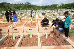 MANGSA DIKEBUMIKAN BERSEBELAHAN: Allahyarhamha Faridah Tamron dan anaknya Allahyarhamha Nur Hazimah Mustafa dan seorang lagi mangsa kemalangan bas di Muar, Johor, Sabtu lalu, Allahyarhamha Hamimah Mammu, telah dikebumikan bersebelahan satu sama lain, di tanah perkuburan Islam Chua Chu Kang, kelmarin. - Foto THE STRAITS TIMES