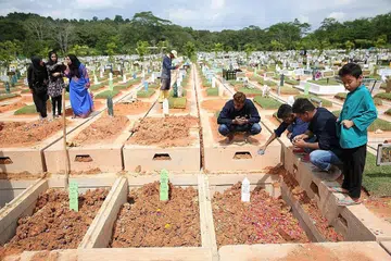 MANGSA DIKEBUMIKAN BERSEBELAHAN: Allahyarhamha Faridah Tamron dan anaknya Allahyarhamha Nur Hazimah Mustafa dan seorang lagi mangsa kemalangan bas di Muar, Johor, Sabtu lalu, Allahyarhamha Hamimah Mammu, telah dikebumikan bersebelahan satu sama lain, di tanah perkuburan Islam Chua Chu Kang, kelmarin. - Foto THE STRAITS TIMES