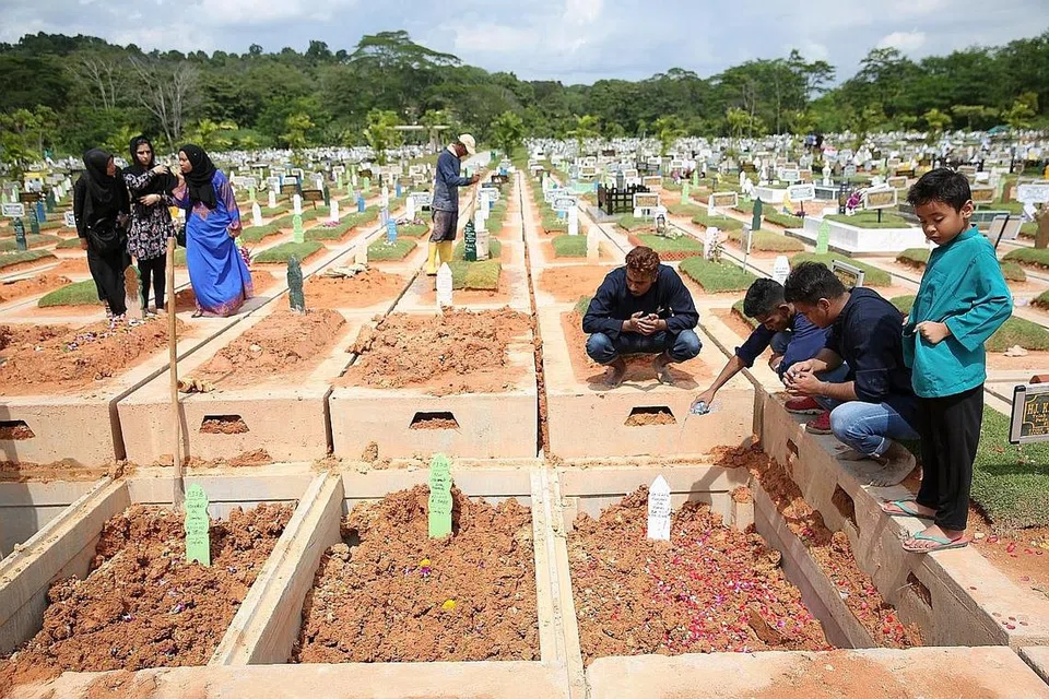 MANGSA DIKEBUMIKAN BERSEBELAHAN: Allahyarhamha Faridah Tamron dan anaknya Allahyarhamha Nur Hazimah Mustafa dan seorang lagi mangsa kemalangan bas di Muar, Johor, Sabtu lalu, Allahyarhamha Hamimah Mammu, telah dikebumikan bersebelahan satu sama lain, di tanah perkuburan Islam Chua Chu Kang, kelmarin. - Foto THE STRAITS TIMES