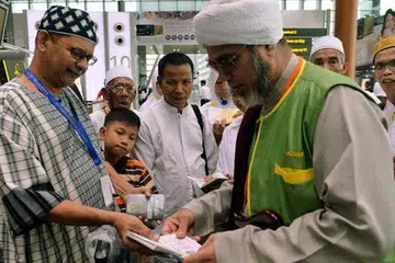 RAMADAN DI TANAH SUCI: Encik Abdullah Moosa (kiri) bersama mutawif, Habib Malik Alhadad (kanan), menunaikan umrah bersama isterinya pada akhir Ramadan ini. - Foto KHALID BABA