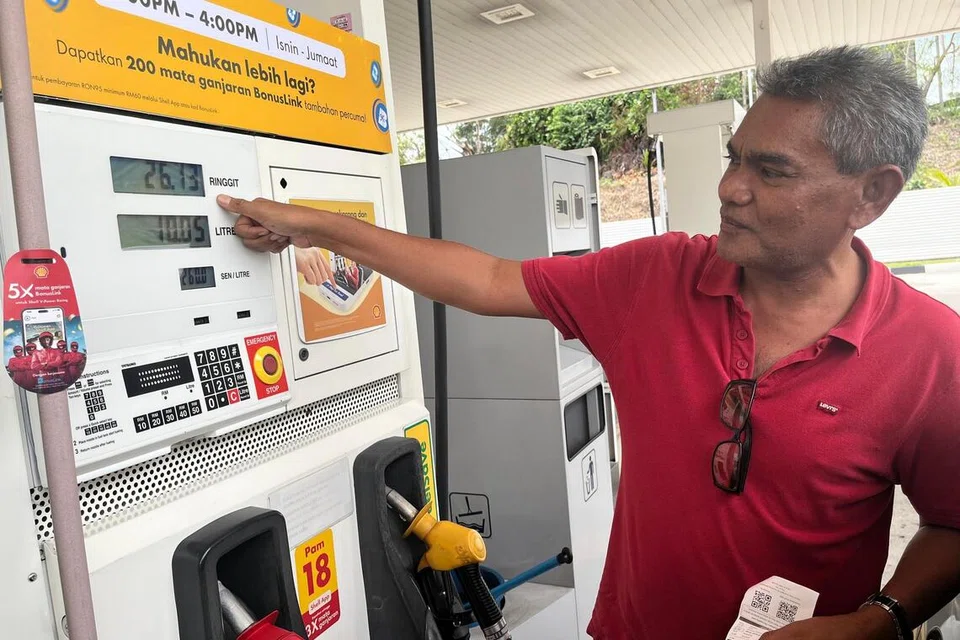 Penyelia elektrik syarikat swasta, Encik Rosman Hadzir, 54 tahun, menunjukkan harga petrol RON95 tanpa subsidi yang dipaparkan di pam minyak, berbanding harga dicetak pada resit.