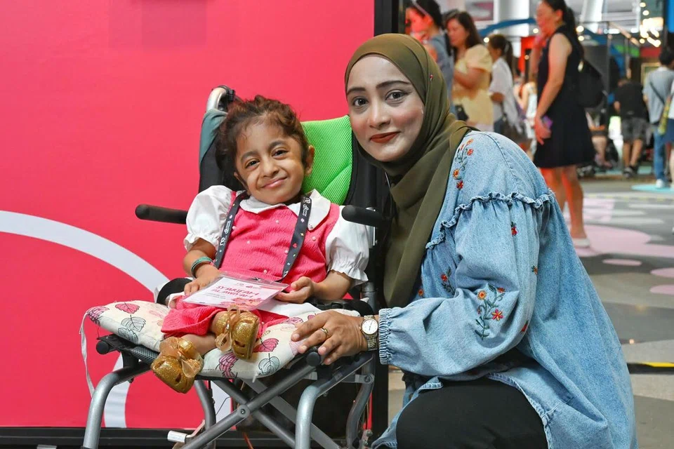 Cik Nor Hidayah Alaudin (kanan) berharap masyarakat dapat melihat keupayaan golongan kurang upaya dan tidak membataskan mereka berdasarkan keadaan fizikal. Beliau hadir bersama anak keduanya, Syarifah Alawiyah Alayrus Syed Abdul Kadir, semasa pelancaran acara seni inklusif Shaping Hearts 2026, yang diadakan di Daerah Digital Punggol (PDD), pada 13 September.