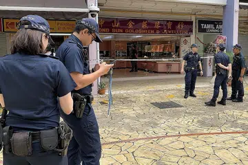 DIROMPAK: Polis melakukan siasatan di kedai emas Tiong Sun Goldsmith & Jewellers di Blok 164 Bukit Merah Central selepas seorang lelaki melarikan diri dengan rantai emas bernilai $3,000 dalam satu kejadian pada Sabtu lalu. - Foto SHIN MIN