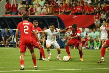 Pemain Lions, Hariss Harun (kanan) dan M. Anumanthan, berebut bola dengan pemain Vietnam, Nguyen Van Quyet (jersi putih), semasa perlawanan Piala Persekutuan Bola Sepak Asean 2022.