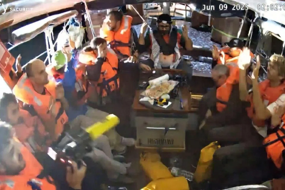 Para penumpang kapal layar, termasuk aktivis, Cik Greta Thunberg, yang membawa beras dan susu formula ke Gaza, mengangkat tangan ketika tentera Israel memasuki kapal itu selepas memintasnya di perairan antarabangsa.