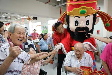 CERIAKAN SUASANA: Sekumpulan 120 warga emas di Pusat Kegiatan Warga Emas Care Corner di Woodlands terhibur dengan kehadiran God of Fortune dalam acara tahunan SPH Cares with Bags of Love yang diadakan semalam. - Foto BH oleh ONG WEE JIN